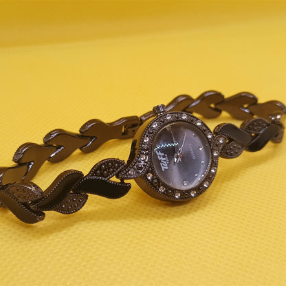 Black chain-link watch on a yellow background
