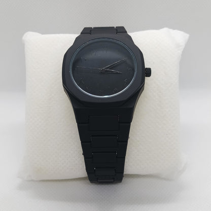 Black wristwatch on a white cushion against a light gray background