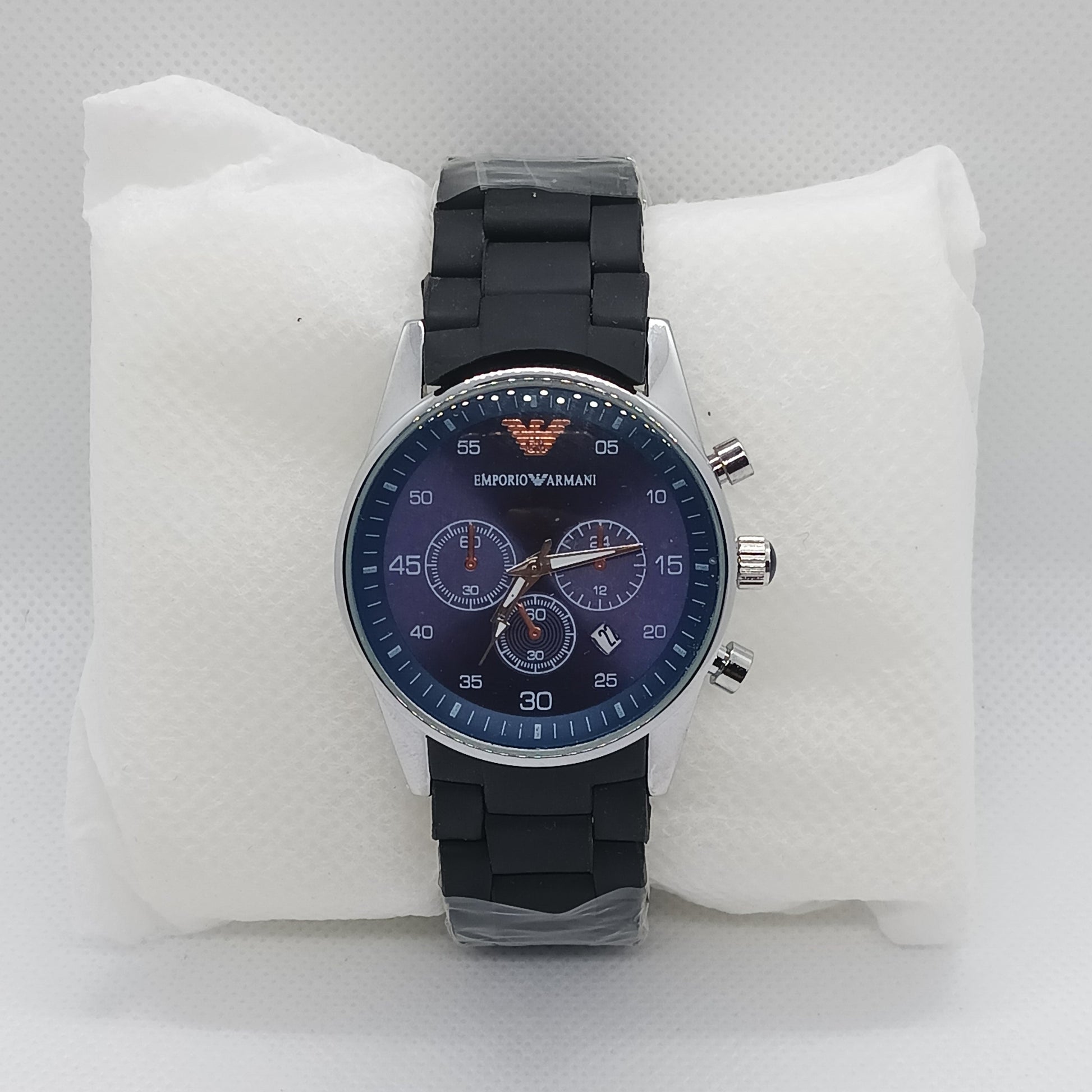 Wristwatch with black strap and blue face on a white cushion