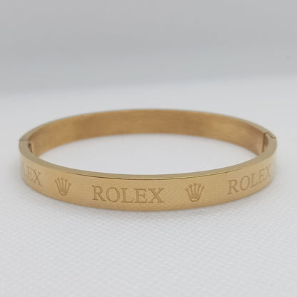 Gold bracelet with 'Rolex' engraving on a white background