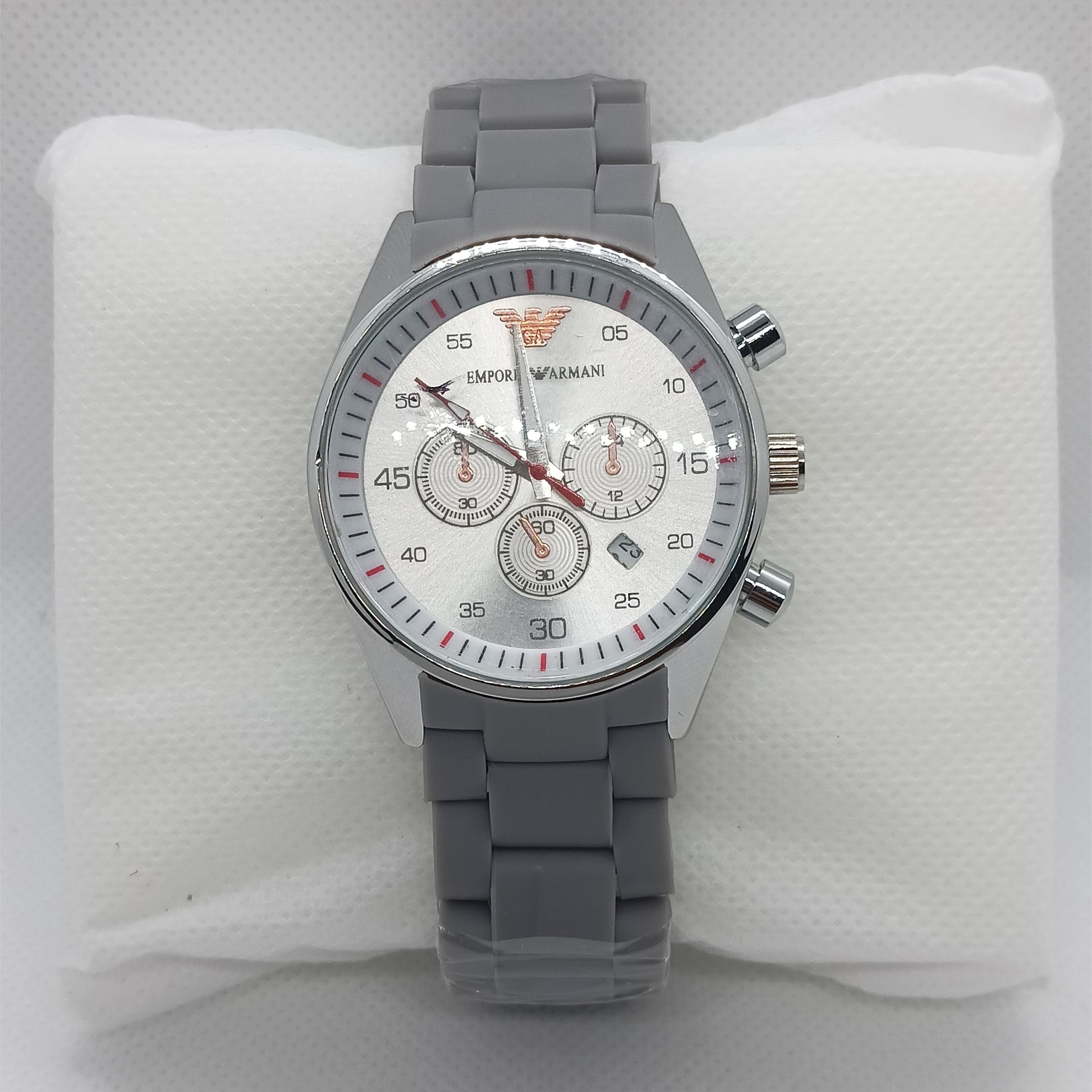 Gray wristwatch with a detailed face on a white cushion