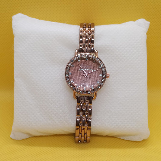 Rose gold watch with gemstone accents on a white cushion against a yellow background