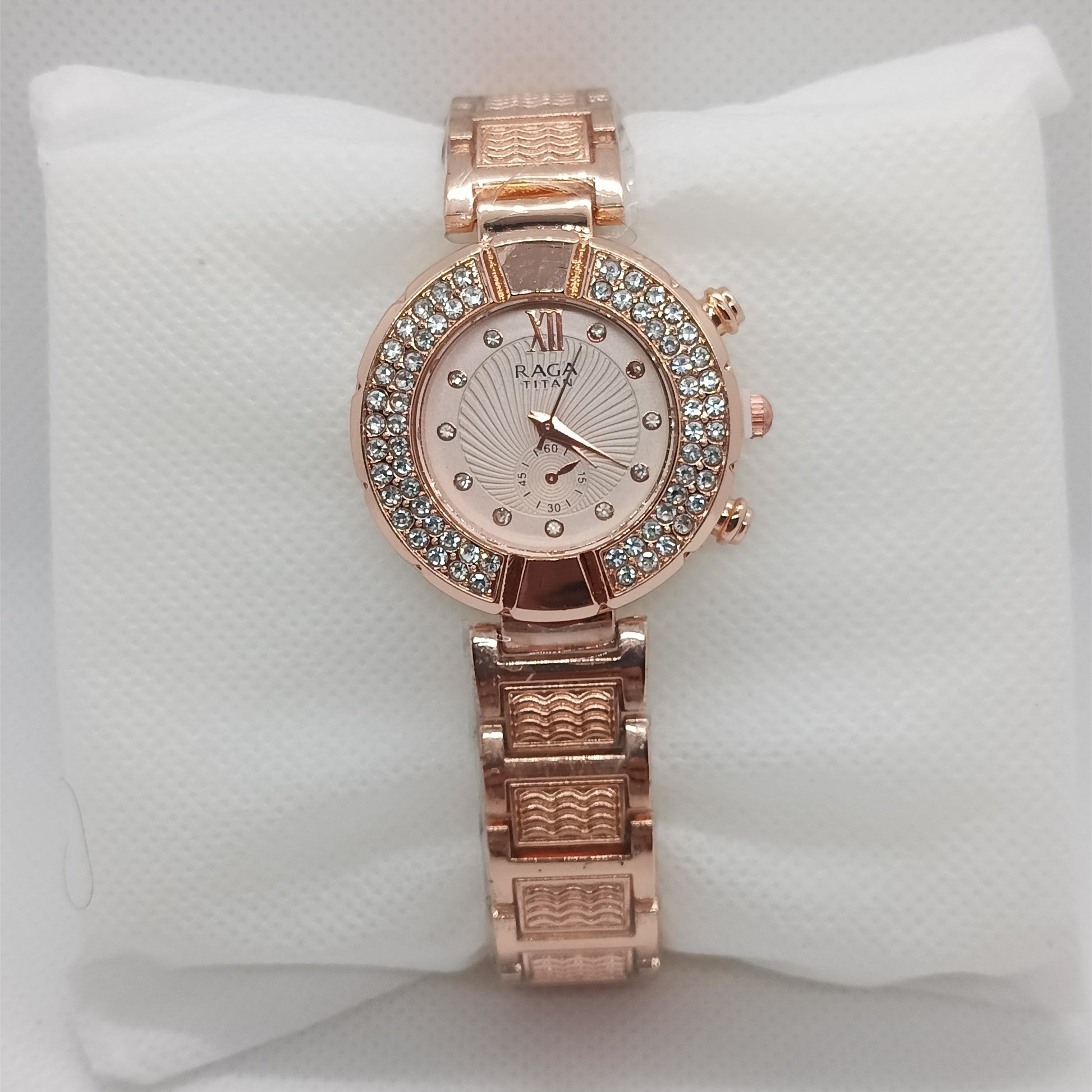 Rose gold watch with gemstone accents on a white cushion