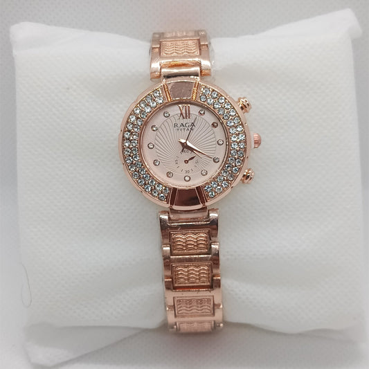 Rose gold watch with gemstone accents on a white cushion