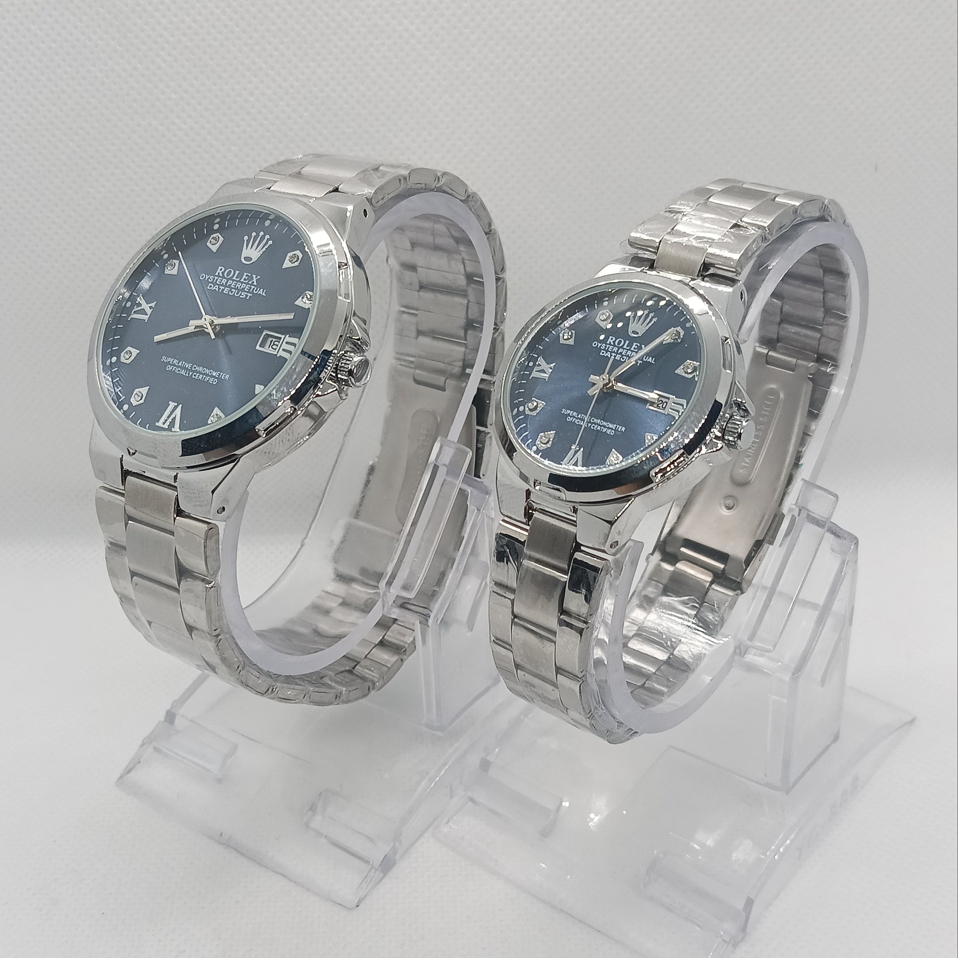 Two silver watches with blue faces on a white background